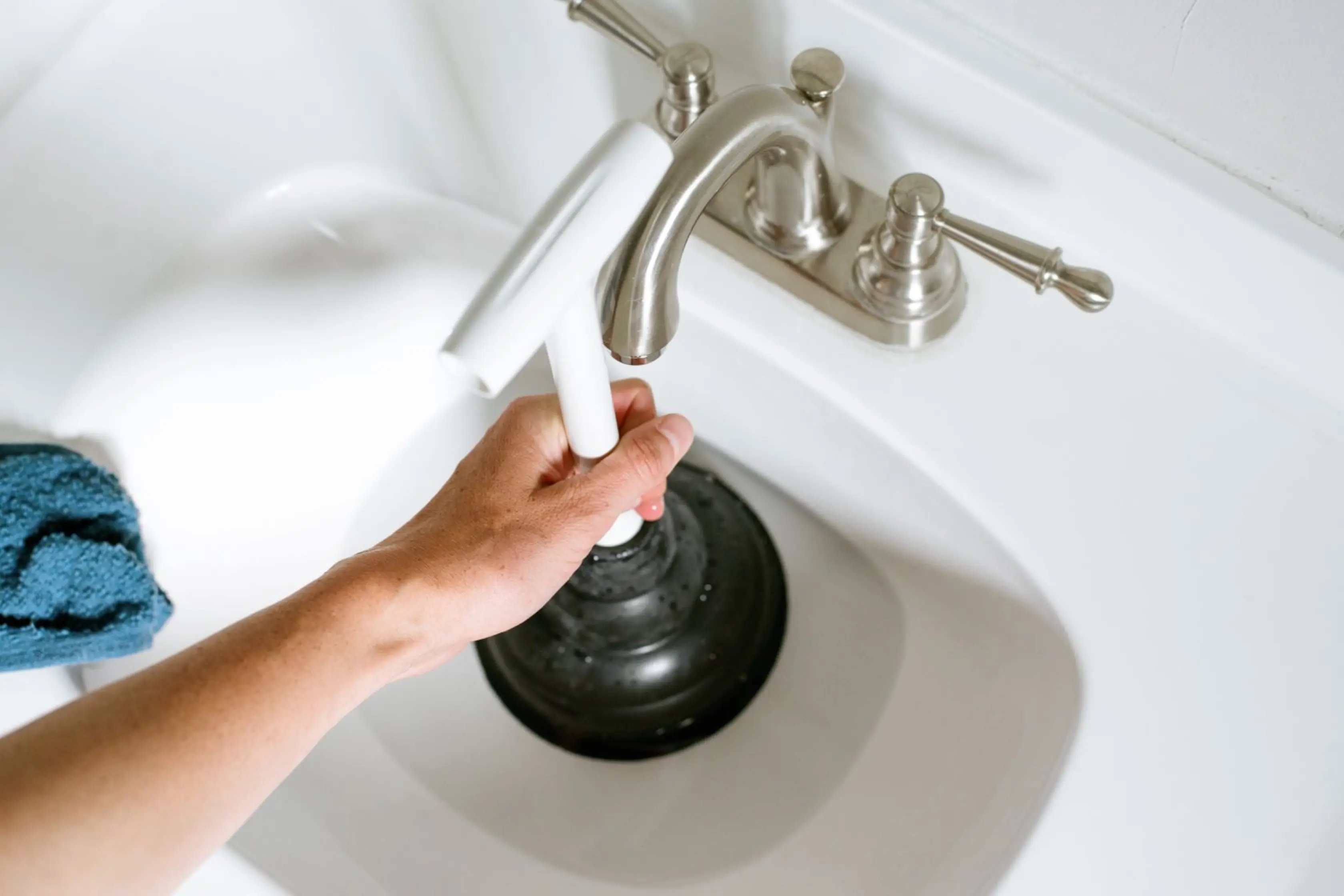 Homeowner Using Plunger To Fix Blocked Sink